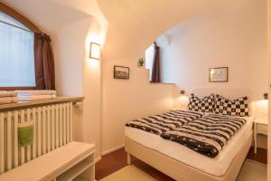 ein kleines Schlafzimmer mit einem Bett und einem Fenster in der Unterkunft Apartment Eva in Bozen