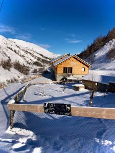 a house in the snow with a fence in front of it at La Ferme des Étroits in Valloire