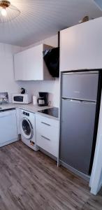 a kitchen with a refrigerator and a washing machine at Résidence Nathalie in Royan