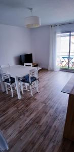 - un salon avec une table et des chaises blanches dans l'établissement Résidence Nathalie, à Royan