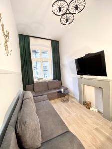 a living room with a couch and a flat screen tv at Angel Apartment Taczaka in Poznań