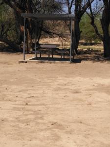 a picnic shelter with a picnic table in a park at Old Bridge Camping in Maltahöhe