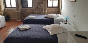 2 Betten in einem kleinen Zimmer mit Fenstern in der Unterkunft Casa Dom Yahya in Belmonte