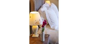 a hotel room with a table with a lamp and flowers at The Blue Ball Inn in Sidmouth