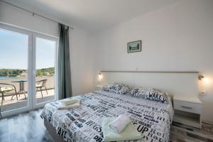 a bedroom with a bed and a large window at Picić Guesthouse in Luka