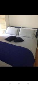a bed with blue and white sheets and pillows at Appartamento il pozzo in Lecco