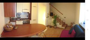 a kitchen with a wooden table and a dining room at Appartamento il pozzo in Lecco