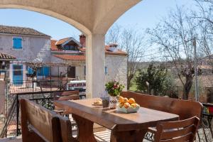 una mesa de madera con un bol de fruta en el balcón en Apartments Fabich, en Veleniki