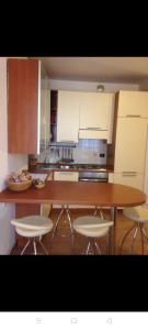 a kitchen with a wooden table and white cabinets at Appartamento il pozzo in Lecco