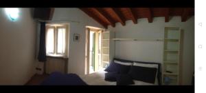 a bedroom with a bed with blue pillows and a window at Appartamento il pozzo in Lecco
