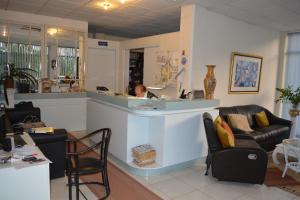 a woman sitting at a counter in a salon at Lefka Ori City Rooms in Chania Town