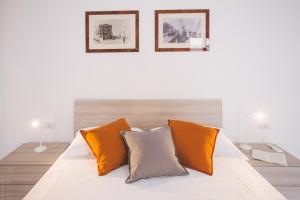 a bed with orange and white pillows in a room at Dimore delle Zagare - Savoia in Siracusa