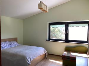 a bedroom with a bed and a window at Guest House Atostogana in Druskininkai +9 photos