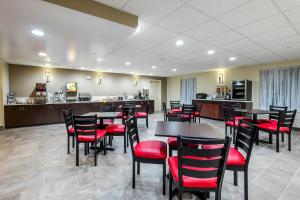 a restaurant with tables and red chairs and a counter at Red Roof Inn PLUS+ Tuscaloosa - University in Tuscaloosa