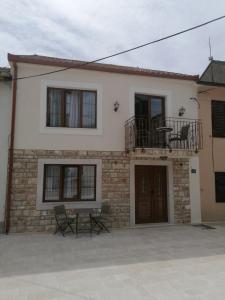 a house with a balcony and chairs in front of it at VILA MIRA in Trebinje