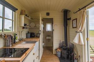 a kitchen in a tiny house with a stove at Rumwold by Bloom Stays in Ashford