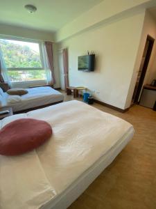 pokój hotelowy z 2 łóżkami i telewizorem w obiekcie DooDoo B&B w mieście Jiji
