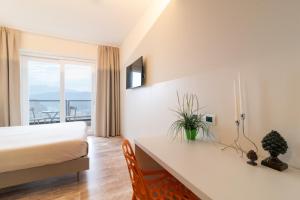 a hotel room with a bed and a desk and a window at Hotel Ristorante Stampa in Lavena Ponte Tresa