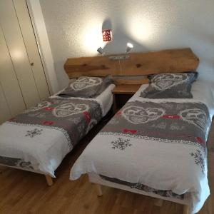 a bedroom with two beds and a lamp on the wall at La pradella Bolquere in Bolquere Pyrenees 2000 +16 photos