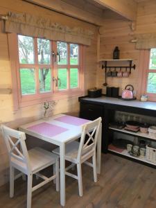 a kitchen with a table and chairs in a cabin at 83 Bredynki in Biskupiec