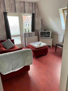 sala de estar con sofá y TV en Appartement De Kaai, en Sint Annaparochie