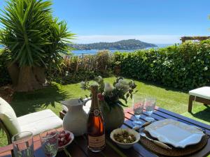 una mesa con una botella de vino y un bol de fruta en La Barmassa, en Villefranche-sur-Mer