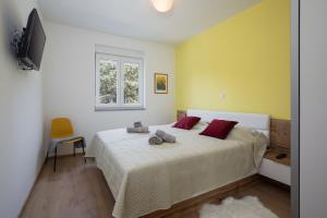 um quarto com uma cama com almofadas vermelhas e uma janela em Apartments Jan&Enzo em Medulin