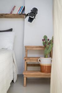 roślina siedząca na półce obok łóżka w obiekcie Relais Bellavista 5 w mieście Miniera dellʼArgentiera