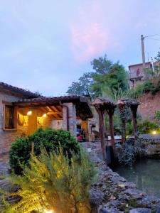 a house with a river in front of a building at Mulino Sandaci - Casa Vacanze in Montefotogno