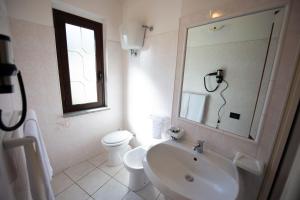 uma casa de banho com um lavatório, um WC e um espelho. em B&B Esterita em Parghelia