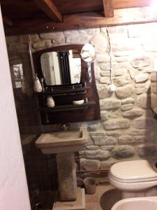 a stone bathroom with a sink and a toilet at Mulino Sandaci - Casa Vacanze in Montefotogno