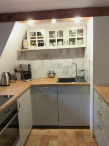a kitchen with white cabinets and a sink at Dom nad jeziorem in Studzienice +11 photos