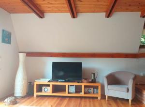 a living room with a tv and a chair at Dom nad jeziorem in Studzienice