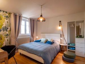 um quarto com uma cama, uma secretária e uma cadeira em Gîte Les Volets Bleus em Boersch