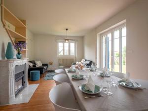 a dining room with a table and chairs and a fireplace at Gîte Les Volets Bleus in Boersch