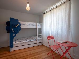 1 dormitorio con litera, mesa y silla en Gîte Les Volets Bleus en Boersch