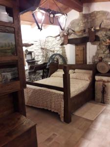 a bedroom with a bed and a stone wall at Mulino Sandaci - Casa Vacanze in Montefotogno