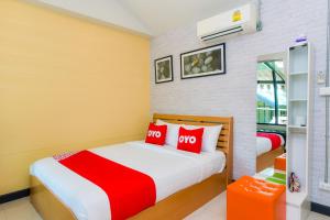 a bedroom with two beds with red pillows at OYO Capital O 390 Nana River Kaeng Krachan in Kaeng Krachan