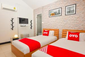 two beds in a room with red and white at OYO Capital O 390 Nana River Kaeng Krachan in Kaeng Krachan