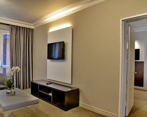 a living room with a couch and a television at ANEW Hotel Centurion Pretoria in Centurion