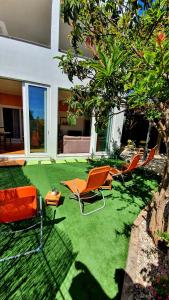 a yard with chairs and tables and a house at Apartments Viki in Split