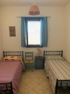 2 camas en una habitación con ventana en Casa Vacanza Almoraima - Salento -, en Bagnolo del Salento