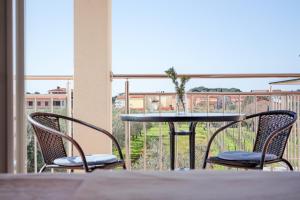 a table with two chairs and a table with a vase on it at KARBONACA APARTMENTS in Fažana