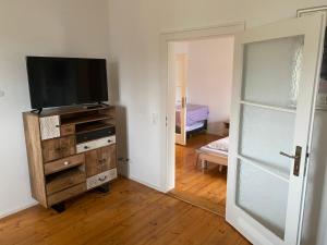 uma sala de estar com televisão numa cómoda de madeira em Ferienwohnungen Jakobsberg em Bamberg