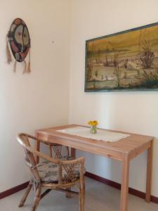 a table and a chair in a room with a painting at Villa Lim in Bergamo