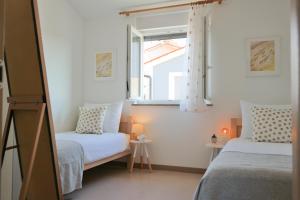 a bedroom with two beds and a window at KARBONACA APARTMENTS in Fažana