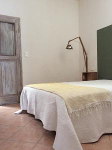 a bedroom with a bed with a white blanket on it at La Maison De Stephanie in Porto-Vecchio