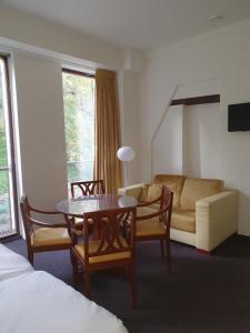 ナイメーヘンにあるHotel Courage Waalkadeのベッド、テーブル、ソファが備わる客室です。