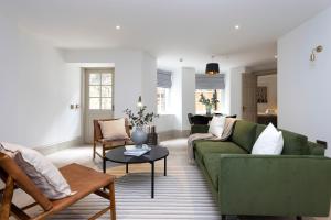 a living room with a green couch and a table at 29 Queen Street Luxury Flats in Edinburgh