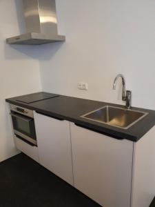 a kitchen with a sink and a microwave at Hotel Courage Waalkade in Nijmegen